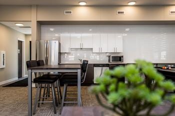 A modern kitchen with a dining table and chairs.